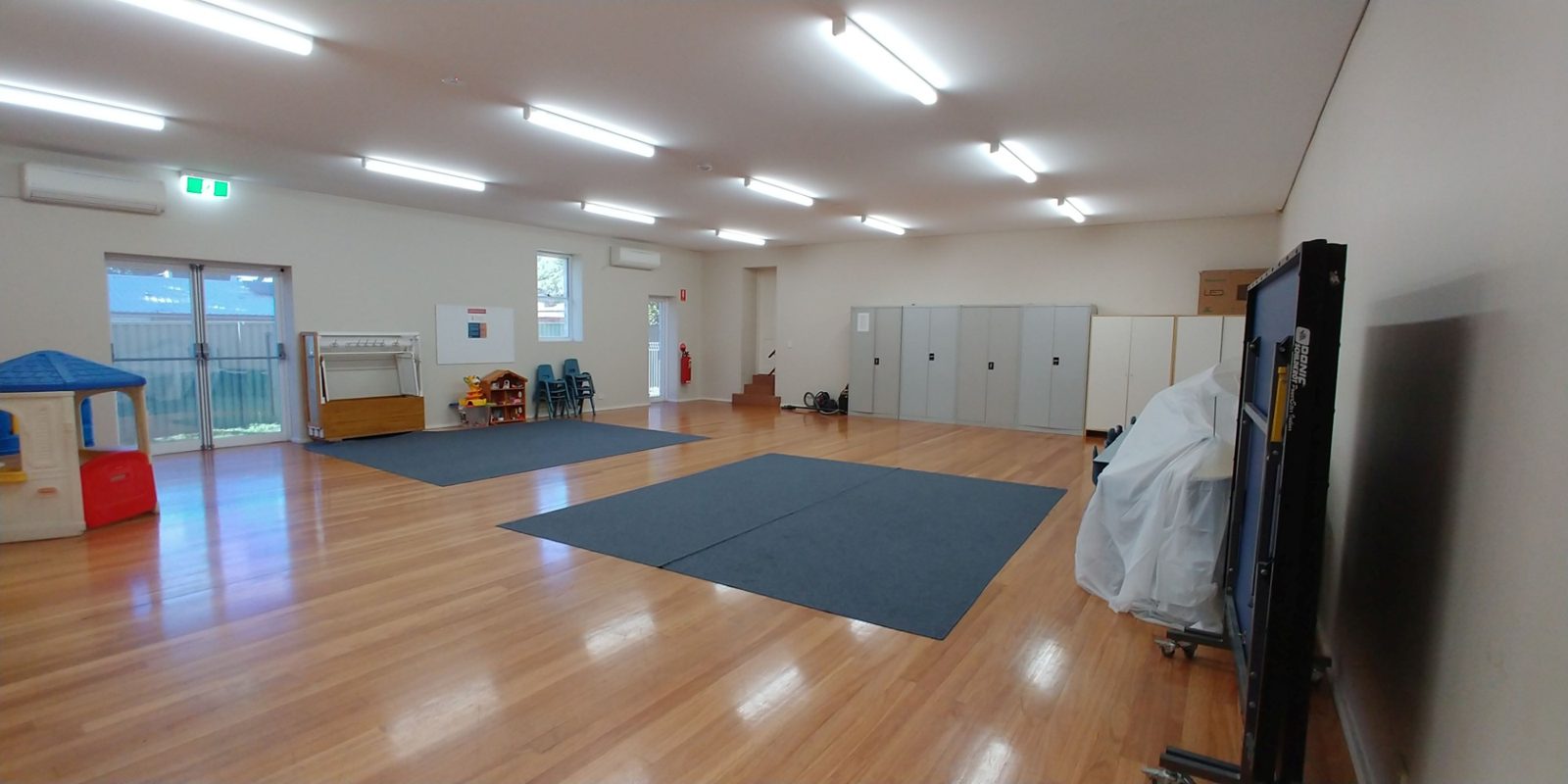 The small hall from the glass doors, with a cubby house and play equipment